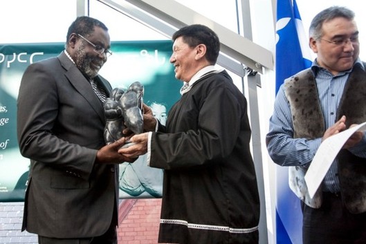 Charlie Arngak giving an Inuit carving to Maka Kotto