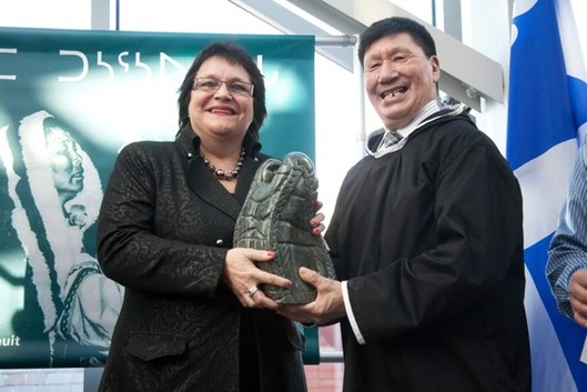 Charlie Arngak giving an Inuit carving to Élizabeth Larouche