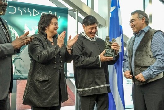 Jobie Tukkiapik giving an inuit carving to Charlie Arngak